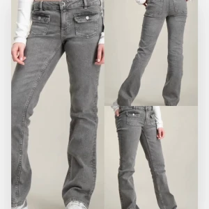 Grå bootcut jeans med fickdetaljer - Snygga grå mid waist jeans med bootcut passform och stora fickor framtill med lock och knapp. 