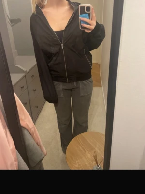 Svart bomberjacka  - Säljer en svart bomberjacka från Pieces med klassisk ribbad krage och muddar. Jackan har dragkedja framtill och två fickor på sidorna. Materialet är lätt och känns skönt mot kroppen, perfekt för lager på lager. Enkel och stilren design som passar till allt.