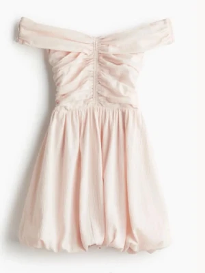 Ljusrosa offshoulder kortklänning - Supersöt ljusrosa kortklänning med offshoulder och rynkade detaljer upptill. Kjolen är puffig och ger en ballongliknande siluett. Tillverkad i ett tunt, mjukt tyg som känns luftigt och somrigt. Perfekt för dig som vill ha en romantisk och trendig look.