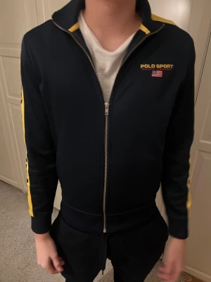 Polo Sport overshirt - Mörkblå jacka från polo sport i storlek XL barnstorlek vilket motsvarar XS/S, killen är 185 cm lång. I nyskick 