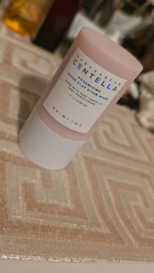 Centella Quick Clay Stick Mask - Centella Quick Clay Stick Mask från SKIN1004 är en ansiktsmask i stiftform med rosa och vit förpackning. Innehåller ren centella från Madagaskar och är enkel att applicera tack vare sin smidiga stick-design. Perfekt för dig som vill ha en snabb och effektiv lermask. Använd en gång 