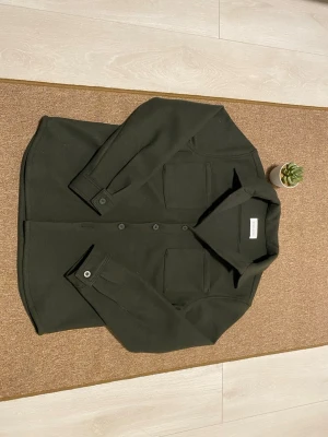 Mörkgrön overshirt från Pier one -  Helt ny och oanvänd mörkgrön overshirt från Pier One utan pristag. En stilren och tidlös design. Den djupa gröna tonen ger ett elegant uttryck, medan det mjuka materialet och den bekväma passformen gör den perfekt för både vardag och fest. Storlek S men passar Storleken M helt utmärkt. Pris kan diskuteras🙌🏻