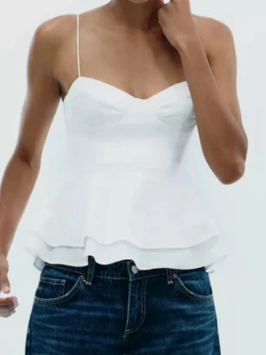 Vit peplum linnetopp från Zara - Supersöt vit linnetopp från Zara med tunna axelband och peplumvolang nedtill. Den är helt ny och det är inget fel på den och den är aldrig använd