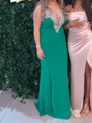 Festklänning  - Säljer en snygg grön långklänning med djup v-ringning och silvriga spetsdetaljer vid bysten. Klänningen har bara använts i några timmar 🫶🏼 M-L