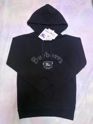 Burberry Hoodie - Hej! Säljer en snygg och stilren svart hoodie från Burberry. Den svarta färgen gör den enkel att matcha med allt och funkar lika bra till vardags som till en mer clean outfit. Perfekt för dig som vill ha både komfort och lyx i ett och samma plagg 😊❄️