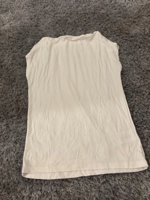 Vit ärmlös linnetopp från lager 157 - Säljer en enkel och stilren vit linnetopp från lager  157 i storlek S. Toppen är ärmlös och har en rak, normal passform. Perfekt för varma dagar och enkel att matcha med olika outfits. Materialet känns mjukt och lätt mot huden.
