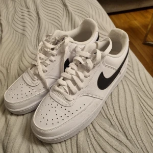 Vita Nike sneakers med svart swoosh - Säljer ett par fräscha vita Nike sneakers