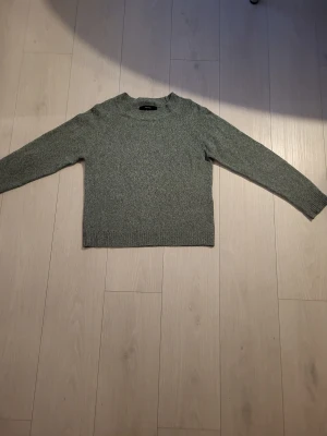 Grön stickad tröja Vero Moda - Säljer en enkel och snygg grön stickad tröja från Vero Moda.. Tröjan har rund hals och långa ärmar med ribbade muddar. Perfekt för dig som gillar en clean och chill stil. Passar dig som vill ha en normal passform och mjukt material.