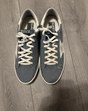 Golden Goose blå sneakers med stjärna - Säljer dessa feta Golden goose, har användt de ett fåtal gånger men de ser exakt som nya. Skriv till mig vid några funderingar. Pris går att diskuteras ‼️box ingår ej eller dustbag bara skorna 
