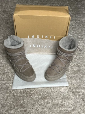 Inuikii boots - Hej nu säljer vi dessa helt nya Inuikii boots i en härlig beige färg. Varmt och bekväm fodring inuti som håller dig varm samt fodring på innersulan. Storlek: 38, innersulan på de dessa är ca 23-24cm. För fler frågor eller funderingar är det bara att skriva och höra av sig  