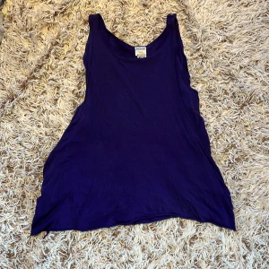 Lila linnetopp från Monki - Säljer en lila linnetopp från Monki i storlek medium. Toppen har djupa ärmhål och är ärmlös, perfekt för varma dagar. Tillverkad i mjuk bomull och har en enkel, loose passform. Snygg att styla med jeans eller shorts. Tröjan är inte i sitt bästa skick. Den ha hål och är lite smutsig. Smutset försvinner i tvätten. Linnet är som två linnen i ett. Storlek M Från Monki