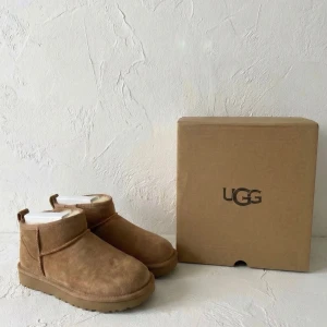 NYA UGG Classic Ultra Mini - Chestnut (Originalförpackning) ✨ - Säljer fabriksnya UGG Classic Ultra Mini i färgen Chestnut. Skorna är helt oanvända och ligger i sin originalkartong. Produktinformation: 🧸 Modell: Classic Ultra Mini 🤎 Färg: Chestnut (Ljusbrun) ✨ Skick: 10/10 (Helt nya/Oanvända i box) 📦 Leverans: Levereras i tillhörande skokartong. Skorna skickas spårbart och säkert emballerat. 