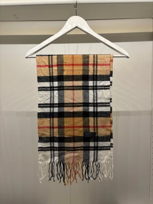 Vintage Burberry Scarf Halsduk - -Riktigt bra skick, knappt använd. Nypris på dessa ligger på runt 5000kr, vilket gör detta till ett sjukt bra pris! Halsduken är gjord i Lamull, och är perfekt inför hösten och den kommande vintern. Anledningen till att det står ”Burberry’s” och inte ”Burberry” på lappen är eftersom halsduken är från några år tillbaka, innan de bytte namn! Om du har någon fråga är det bara att skriva till mig. /elgnce