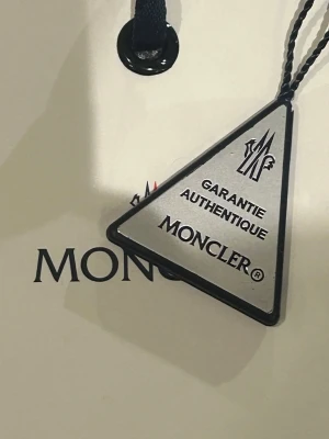 Moncler cardigan - En Moncler cardigan med lappar kvar. En klassisk svart cardigan som värmer under allla årstider och är perfekt för dig som vill slå till på ett relativt billigt lyx-tillägg i din garderob. Tveka inte på att skriva om du har frågor!