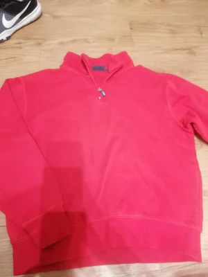Röd half zip tröja från South West - Säljer en röd långärmad tröja från South West med half zip-dragkedja i halsen. Tröjan har en klassisk, enkel design med ribbade muddar och är gjord i mjuk bomull. Perfekt för chill dagar och passar dig som gillar sportig stil. Passar även dig som bär XS/S! 😊