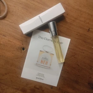 NEH The Element EdP 8 ml - Parfym 8 ml från NEH, The Element EdP, i en smidig glasflaska med silverfärgat hspraylock och orange etikett. Doften har noter av litchi, elemi och kola, med inslag av patchouli och vanilj. Kommer med vit SNIPH-förpackning och informationskort. Från Sniph