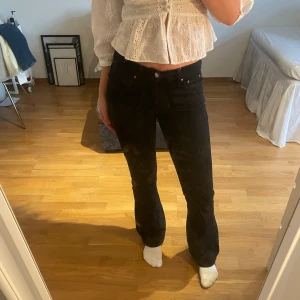 Svarta bootcut jeans  - Snygga svarta jeans med bootcut-modell och hög midja. Jeansen har klassisk femficksdesign, svarta sömmar. Perfekta om du gillar en tidlös look med lite utsvängda ben.