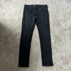 Svarta jeans East West - Svarta Jeans från East west i fint skick. Modell: Bowery = slim modell. Storlek: W32 L34. Fina diskreta detaljer. Säljer för endast 150kr!