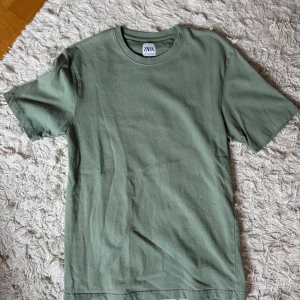 Grön t-shirt från Zara - Enkel och stilren grön t-shirt från Zara i mjuk bomull. Klassisk rund halsringning och korta ärmar. 
