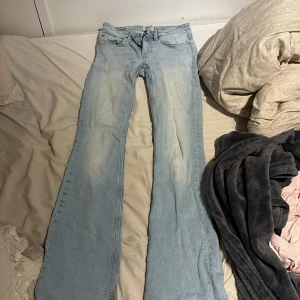 Ljusblå bootcut jeans från 157 - Säljer ett par ljusblå bootcut jeans från 157 med låg midja. Jeansen har klassisk femficksdesign och är tillverkade i mjukt denimtyg. Perfekt för dig som gillar retrovibbar och vill ha en snygg siluett med utsvängda ben.