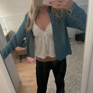 Jeansskjorta från Lee med tryckknappar - Snygg ljusblå jeansskjorta från Lee med klassiska western-detaljer, två bröstfickor och tryckknappar. Skjortan har lång ärm och rak passform, perfekt att bära öppen eller stängd. Materialet är mjukt jeans och skjortan har rå kant nertill för en cool look.