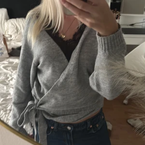 Grå omlottkofta från Even&Odd - Supermjuk grå omlottkofta från Even&Odd med knyt i sidan och ribbade muddar. Perfekt till jeans eller kjol och har en snygg v-ringning. Långärmad och i skönt bomullsmaterial som är perfekt nu när det börjar bli kallare. 🤍