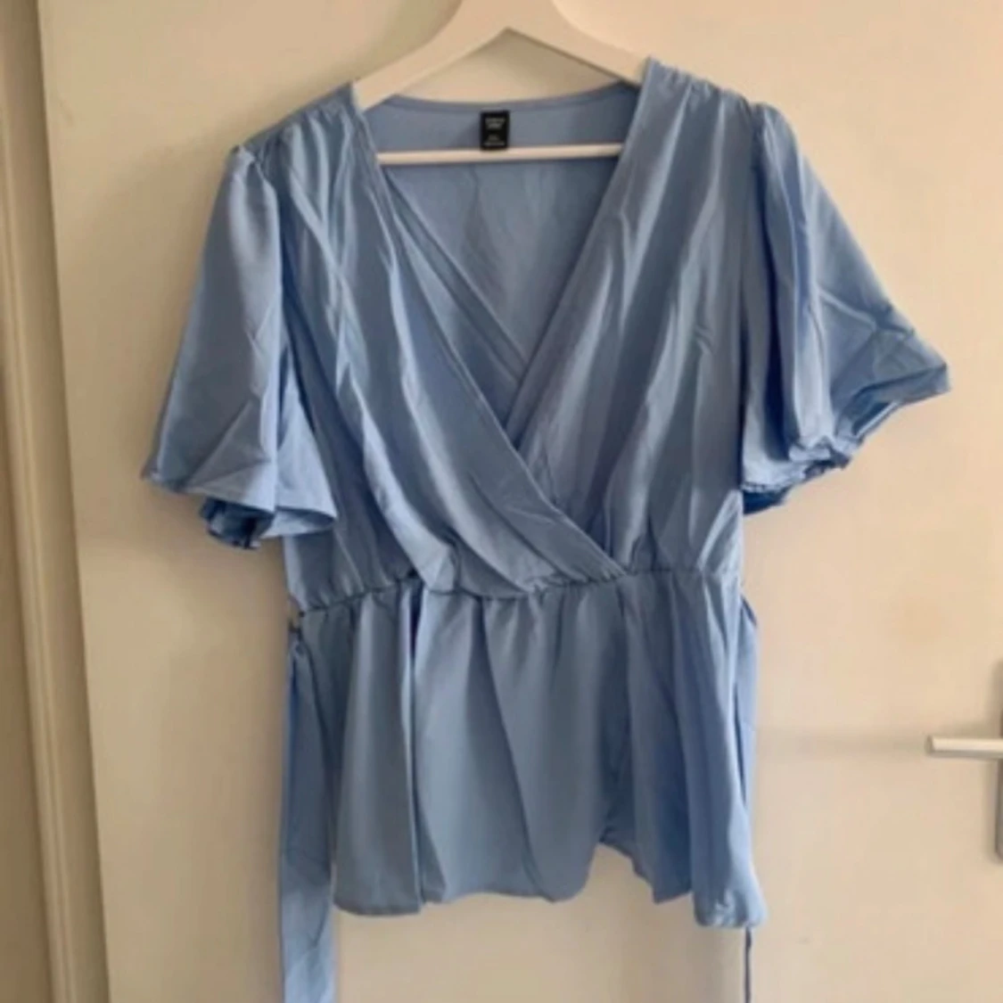 Ljusblå omlottblus med knytband