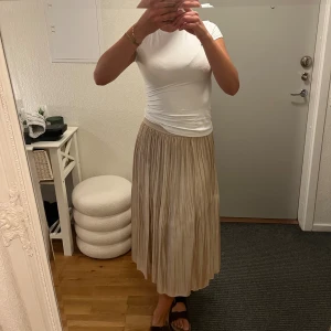 Långkjol - En guldig långkjol. Använd. Inga märkvärdiga defekter. Har underkjol. Strl 38