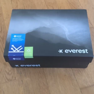 Sneakers strl 38 - Snygga plommonlila sneakers från Everest i storlek 38. Skorna har meshpaneler för bra andning, svarta och vita snören samt en robust vit och grå sula med bra grepp. Perfekta för utomhusaktiviteter och träning. Vattentäta och med låg profil.