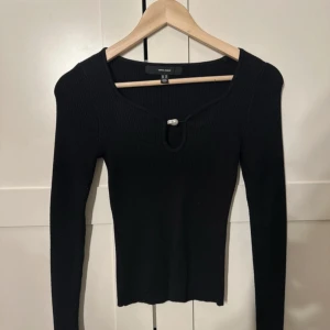  långärmad topp Vero Moda - Svart långärmad topp från Vero Moda med ribbad struktur och en snygg detalj framtill med liten pärla vid halsringningen. 