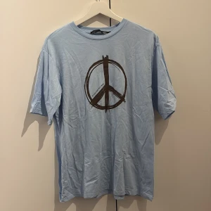 Ljusblå t-shirt med peace-tryck - T-shirt från Lager