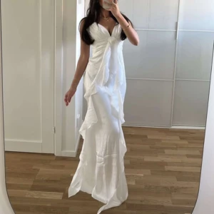 Långklänningfrån Bella Barnett - Säljer en elegant vit långklänning från Bella Barnett. Perfekt för speciella tillfällen och ger en romantisk känsla. Aldrig användn! 