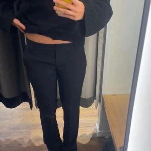 Svarta kostymbyxor med raka ben - Säljer ett par svarta kostymbyxor med raka ben och klassisk passform. Byxorna har diskreta fickor i sidorna och hällor för bälte. Perfekta för en clean och stilren look. Materialet känns mjukt och följsamt. (LÅNADE BILDER)