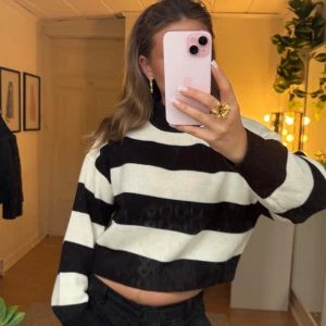 Randig stickad polotröja - Säljer en randig svartvit stickad tröja. Den har en polokrage. Tröjan är lite kortare nertill men absolut inte för kort (precis över kanten på byxorna om man har väldigt lågmidjat) men är bra längd i armarna. Den är ytterst sparsamt använd. Kolla bion innan köp.