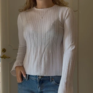 Vit långärmad topp BikBok  - Vit, långärmad topp ifrån BikBok. Absolut ÄLSKAR denna, men jag har dubbletter så säljer en. Små volanger i ärmslut och längst ner, lite genomskinlig. Storlek S, jättefint skick! 