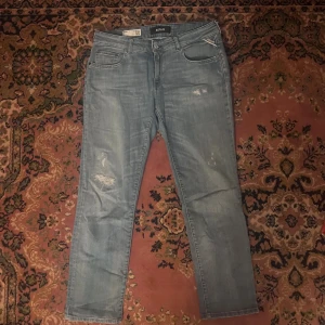 Replay Faaby ljusblå jeans, slim 30/28 - Säljer ett par Replay Faaby jeans i ljusblå tvätt med slitna detaljer och slim fit. Klassisk femficksmodell, raka ben och normal midja. Jeansen är tillverkade i mjukt denimtyg och har snygga slitningar på låret och knät för en avslappnad look. Midja 40cm längd 95cm (38)