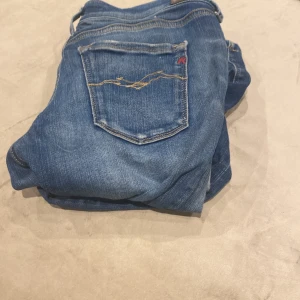 Blå Replay jeans - Snygga blå skinny jeans från Replay med klassisk femficksdesign och broderad bakficka. Jeansen har en smal passform och är tillverkade i mjukt jeanstyg som sitter tajt längs benen. Perfekta för dig som gillar en stilren och modern look. Kom med bud o frågor priset är inte spikat!