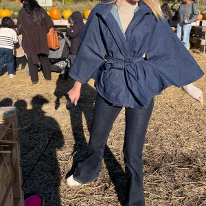 Jeans Cape - Snygg mörkblå cape i jeansmaterial med breda ärmar och knytbälte i midjan. Ett utav vårat första Drops på Évora och det finns endast 2 st i storlek XS/S och S/M. Modellen på bilden har S/M
