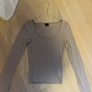 Beige långärmad softtouch topp - Stilren beige långärmad topp med slits i ärmen från Gina Tricot i storlek XS. Toppen har rundad urringning och är tajt modellen. Materialet är soft touch och aldig använd💖📦
