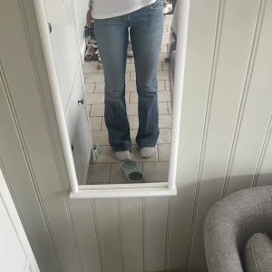Blå bootcut jeans med hög midja - Säljer ett par klassiska blå jeans med bootcut och låg midja. Jeansen har en snygg tvätt och sitter tajt över låren innan de släpper ut vid vaden. Nästan inte ens använda!!💘Står inte vilken storlek men jag har oftast S i byxor och dessa passar mig fint!