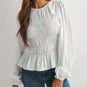 Vit blus med veck från Nelly - Säljer en vit blus från Nelly i storlek 34. Blusen har långärmade ärmar och är tillverkad i ett lätt bomullsmaterial. Den har snygga rynkdetaljer över hela framsidan och baksidan som ger en cool och trendig look. Perfekt för dig som gillar stilrena och fräscha toppar.