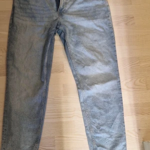 Ljusblå tapered jeans från H&M - Säljer ett par ljusblå jeans från H&M i tapered modell med regular fit. Klassisk femficksdesign och tillverkade i jeansmaterial. Perfekta för dig som gillar en avslappnad men ändå snygg look.