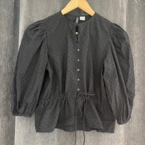 Svart topp/blus med knyten - Går att dra åt knytet i midjan