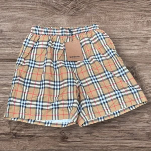 Rutig Burberry shorts i  - Snygga shorts från Burberry med klassiskt rutigt mönster i beige, svart, rött och vitt. De har elastisk midja och är tillverkade i lätt bomull, perfekta för sommardagar. Ikonisk design som ger en clean och trendig look.