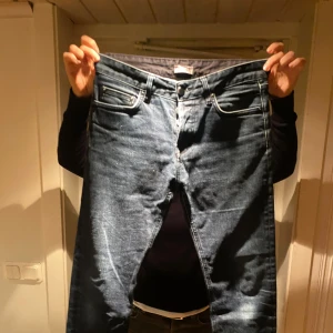 Mörkblå jeans från Filippa K - Snygga mörkblå jeans från Filippa K med klassisk femficksdesign och raka ben. Jeansen har kontrastsömmar, knappstängning och är tillverkade i slitstarkt denim. Storleken är 31/36 använda med uppvikning, se bild 3. 