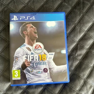 FIFA 18 PS4 - FIFA 18 till PlayStation 4 i mycket fint skick. Komplett med originalfodral och skiva utan synliga repor. Upplev realistisk fotboll med Frostbite-motorn, Ultimate Team och The Journey-läge. Perfekt för fotbollsfans och samlare.
