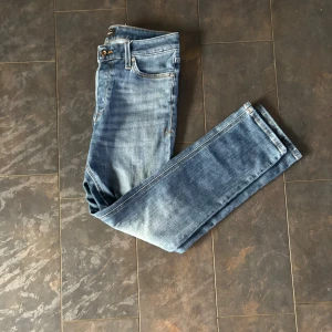 Jack and Jones jeans 28/30 - Snygga blå jeans från Jean Collection i klassisk straight fit. Jeansen har fem fickor, orangea sömmar och en cool tvättad look. Passar dig som gillar en tidlös stil och vill ha ett par jeans som funkar till allt. Midja med knapp och dragkedja.
