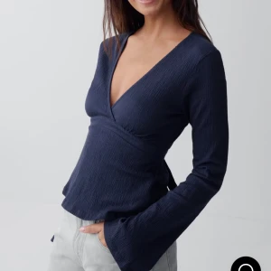 Mörkblå knyt topp - Mörkblå v-ringad topp du knyter i ryggen, skitsnygg men kommer inte till användning. Använt 4 gånger typ. Kostar 300kr i nypris från Gina tricot 