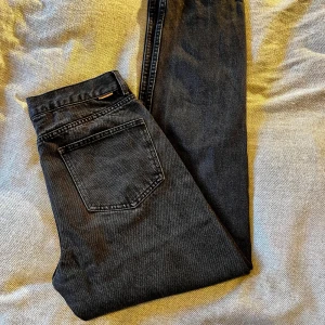 Svarta straight jeans Studio Total - Snygga svartgrå jeans från Studio Total i rak modell. Jeansen är tillverkade i en mix av bomull och polyester och har klassisk femficksdesign med silverfärgade nitar. Perfekta för dig som gillar en clean och tidlös look.