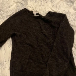 Mörkgrå stickad tröja Arnie Says - Säljer en mörkgrå stickad tröja från Arnie Says, tillverkad i Italien. Tröjan har en klassisk rund hals och långa ärmar, perfekt för dig som gillar enkel och stilren design. Materialet är mjukt och ger en skön känsla mot huden.Bra matrial inte polyester